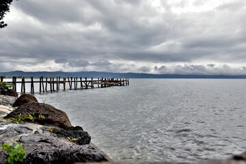 Fototapeta premium Steg im Bolsenasee unter Gewitterwolken