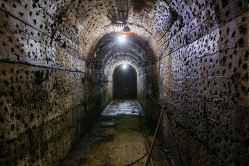 Vaulted tunnel with concrete walls in old abandoned bunker, mine, drainage, subway, etc