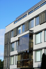 View to white appartment building with wooden details towards blue sky. Tallinn, Estonia