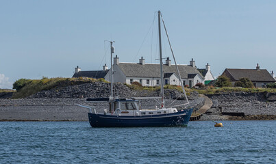 Obraz premium Sailing boat moored in the se next to an island