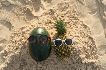 Obraz premium Fruit man made of pineapple and watermelon on the beach fruit tourism for health Funny and cute sunbathing fruits. Festive food. Summer travel concept. white background design invitation to visit