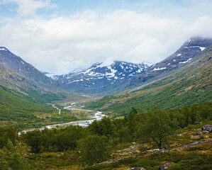 Summer cloudy mountain landscape with river (Norway).