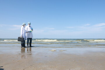 A couple of professional environmentalists discussing working with the pollute of water on the beach