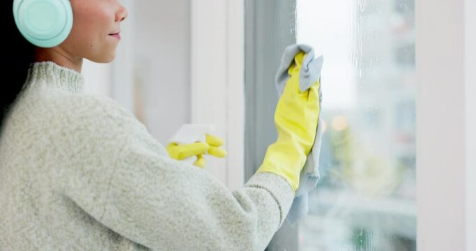 Headphone, window and woman spring cleaning a glass door in home living room as for hygiene, protection or disinfection. Dirt, dust and person or cleaner doing domestic or sanitary housekeeping work