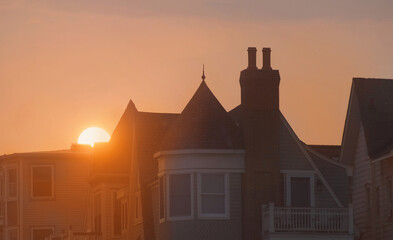 sunset behind victorian houses in a residential suburban neighborhood real estate with vacation rentals