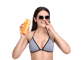 Beautiful young woman in sunglasses holding bottle of sun protection cream on white background