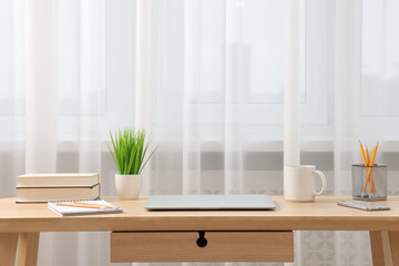 Home office. Stylish workplace with laptop and stationery on wooden desk indoors. Space for text