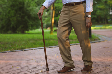 Senior man with walking cane outdoors, closeup