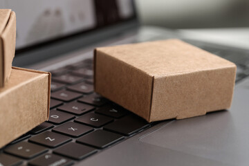 Online store. Small boxes on laptop, closeup