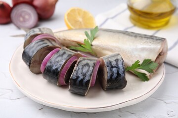 Tasty salted mackerel parsley and onion on white textured table, closeup
