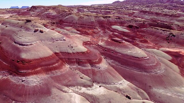 Aerial-Brilliant colored bands of Bentonite Hills. The Bentonite Hills appear as softly-contoured, banded hills in varying hues of brown, red, purple, gray, and green. 