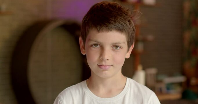 Portrait of young smiling boy student indoors. Person silent focused gaze into camera. Each person is unique, visual depiction personality. Closeup face schoolboy lifestyle portrait. Preteen child.