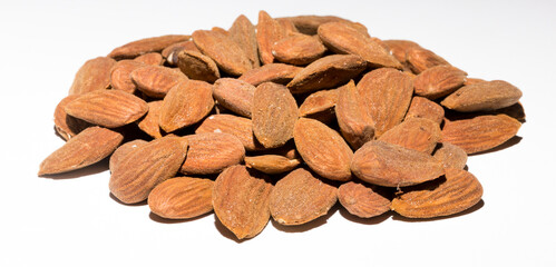 Shelled almonds (Prunus dulcis). A lot of peeled almonds on a white field.