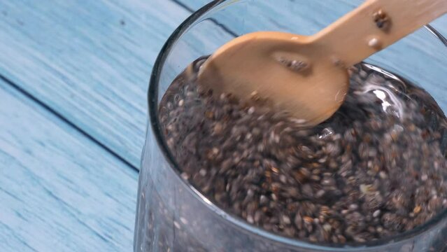 Preparing superfood water drink rich in Omega 3 fatty acids. Pouring coconut water. Adding soaked chia seeds and lemon detox Breakfast. Clean eating, weight loss, dieting food concept Vegetarian