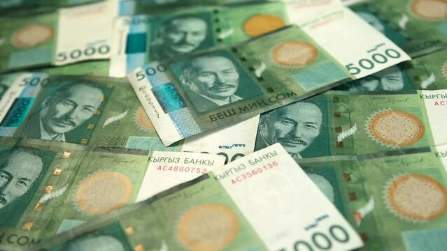 Five thousand som cash Kyrgyz Republic national paper currency money background, banknotes 5000 Kyrgyz som bills on table. Financial success and abundance.