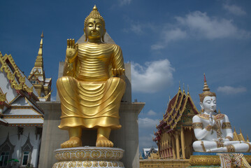 Outdoor large golden Buddha in the sitting position beautiful enshrined in front of the church of Wat Charoenratbamrung or Wat Nong Pong Nok temple. Located at Nakhon Pathom Province in Thailand.
