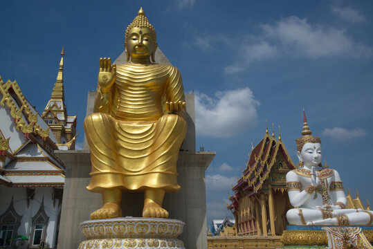 Outdoor large golden Buddha in the sitting position beautiful enshrined in front of the church of Wat Charoenratbamrung or Wat Nong Pong Nok temple. Located at Nakhon Pathom Province in Thailand.