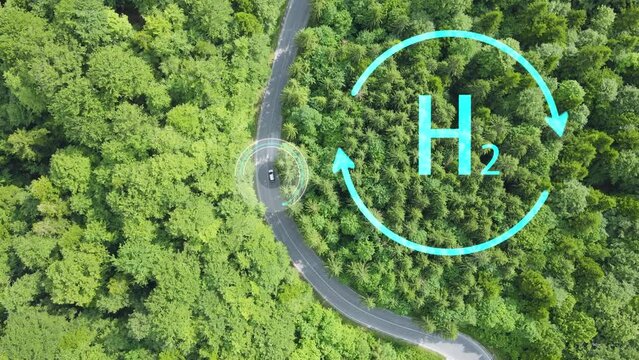 Aerial top down of hydrogen car driving on switchback mountain road with green natural unpolluted forest. Animation of Hydrogen chemical element symbol h2
