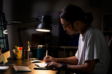 Asian man graphic designer working on computer drawing sketches logo design. The concept of a new...
