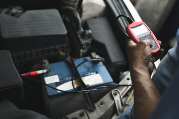 Auto mechanic testing car battery ,car battery tester service.