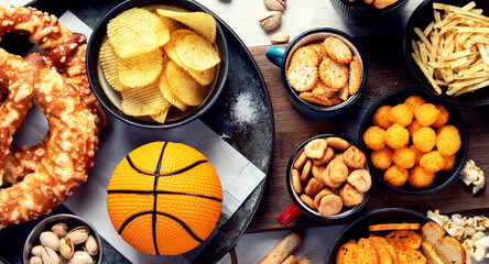 Snacks on white table with basketball ball, game night food.
