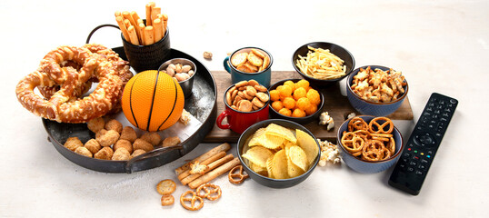 Snacks on white table with basketball ball, game night food.