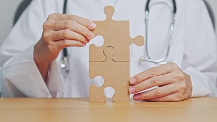 Doctor hand connecting couple puzzle piece, wooden jigsaw in hospital. Teamwork, Idea, Solution, challenge, success, Health, Medical and strategy concepts - Powered by Adobe