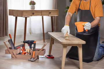 Handyman repair wooden bench in living room.
