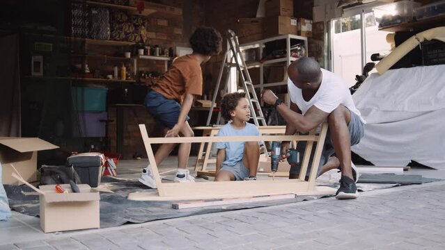 Black Man Builds Table with Sons