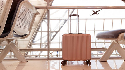 Pink travel suitcases in the airport terminal waiting area, summer vacation concept, traveling and enjoying concept