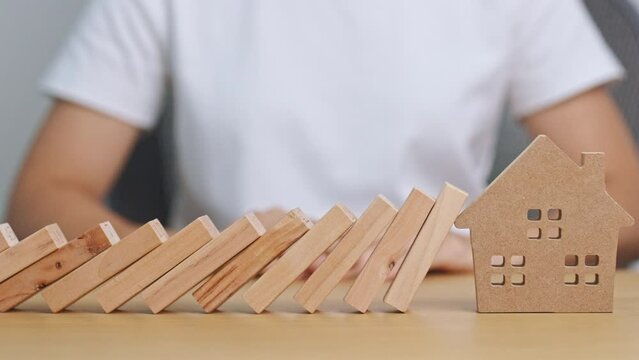 hand stop falling wood blocks and protect house model. Crisis, fall Business, Risk, Economic recession, Developer, Real Estate and Property concept