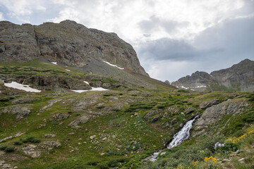 Beautiful scenery with waterfall and mountains in the background. Some snow on the glaciers still there in the Summer