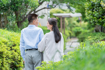 公園を散歩するシニア夫婦