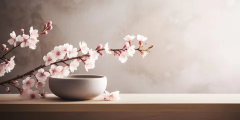 Fototapeten A moody scene of a luxury spa interior with a wooden table, a light colored bowl and a branch with cherry blossoms © Maris