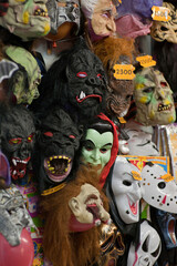 Display wall of halloween scary faces masks on sale in joke shop