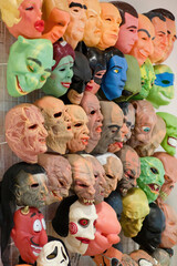 Display wall of halloween scary faces masks on sale in joke shop