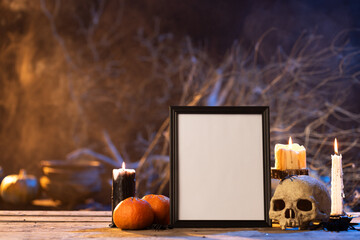 Black frame with copy space, skull, candles and smoke on black background