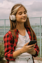 happy teen girl in headphones streetstyle portrait