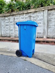 Fototapeta na wymiar blue recycling bin with wheels made of plastic Place it outdoors on the sidewalk to collect garbage outside.