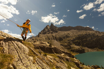Woman climbing high mountains with blue cuelo lake with clouds, hiking having fun