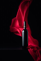 Bottle of red wine and flutters of red cloth.