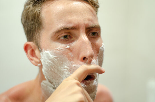 Caucasian man thinking about growing a mustache to support Movember. Awareness of men's health, prostate cancer, testicular cancer, depression and sedentary lifestyle. - Powered by Adobe