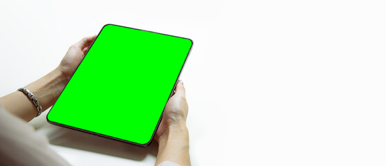 Mockup image, woman holding black digital tablet with blank green screen on white background.