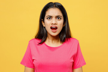 Young sad angry mad furious indignant shocked Indian woman wearing pink t-shirt casual clothes looking camera scream shout isolated on plain yellow wall background studio portrait. Lifestyle concept.