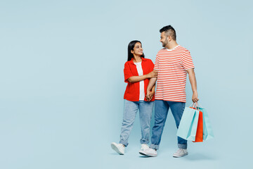 Full body young couple two friends family Indian man woman wear red casual clothes hold package...