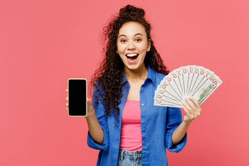 Young woman of African American ethnicity wear blue shirt casual clothes hold fan of cash money in...