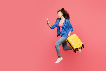 Traveler woman wearing blue casual clothes hold bag mobile cell phone isolated on plain pastel pink background. Tourist travel abroad in free spare time rest getaway. Air flight trip journey concept.