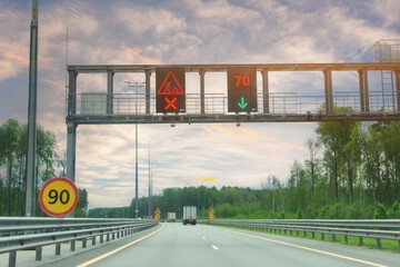 Road with luminous designation banner sign on the road road repair and speed limit 90 and 70 km per...