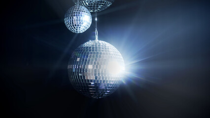 A colorful disco mirror ball illuminates the backdrop of a nightclub. The party lights up the disco ball.