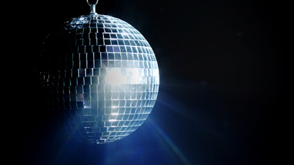 A colorful disco mirror ball illuminates the backdrop of a nightclub. The party lights up the disco ball.